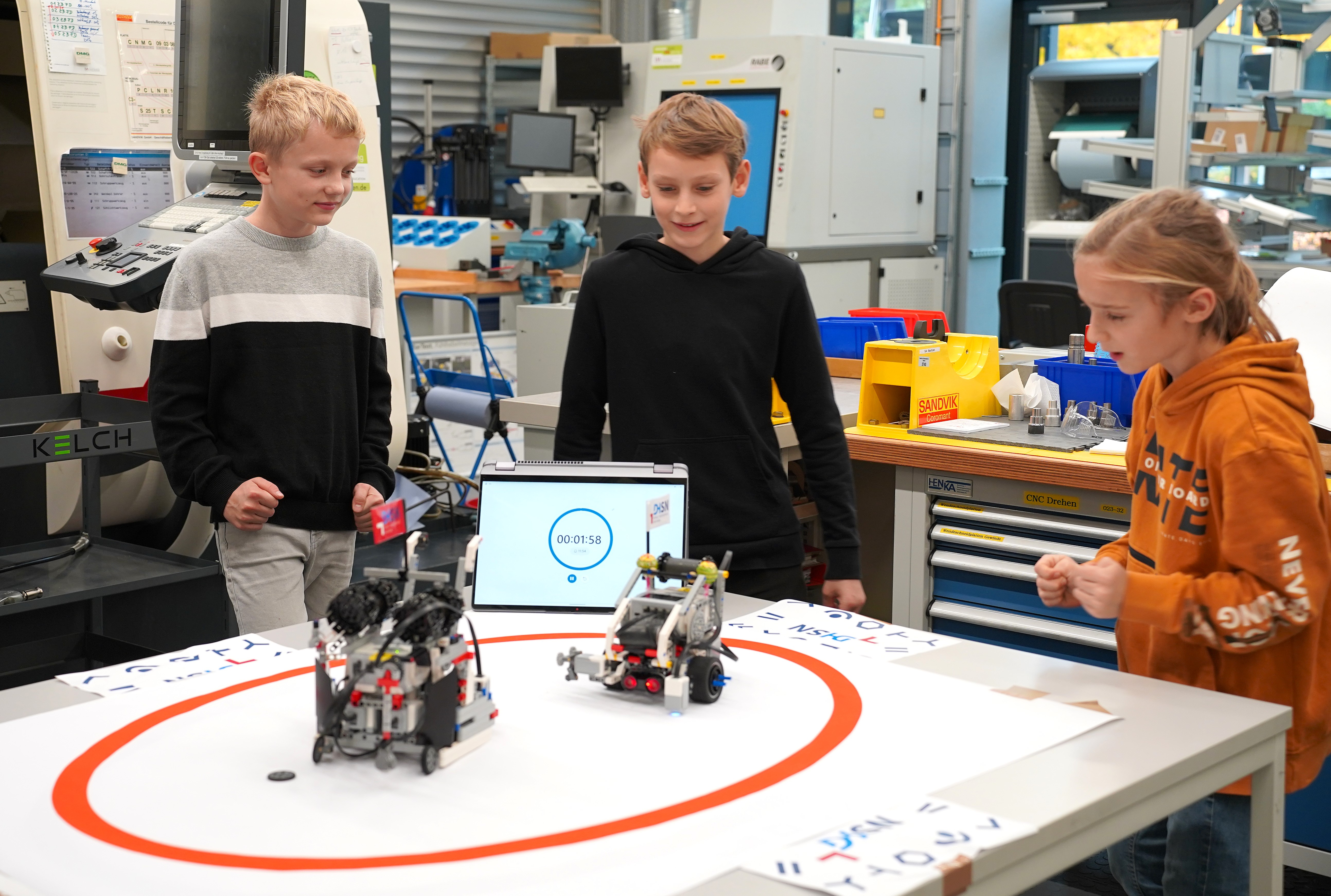 Drei Schüler beim Test der selbst gebauten Roboter.