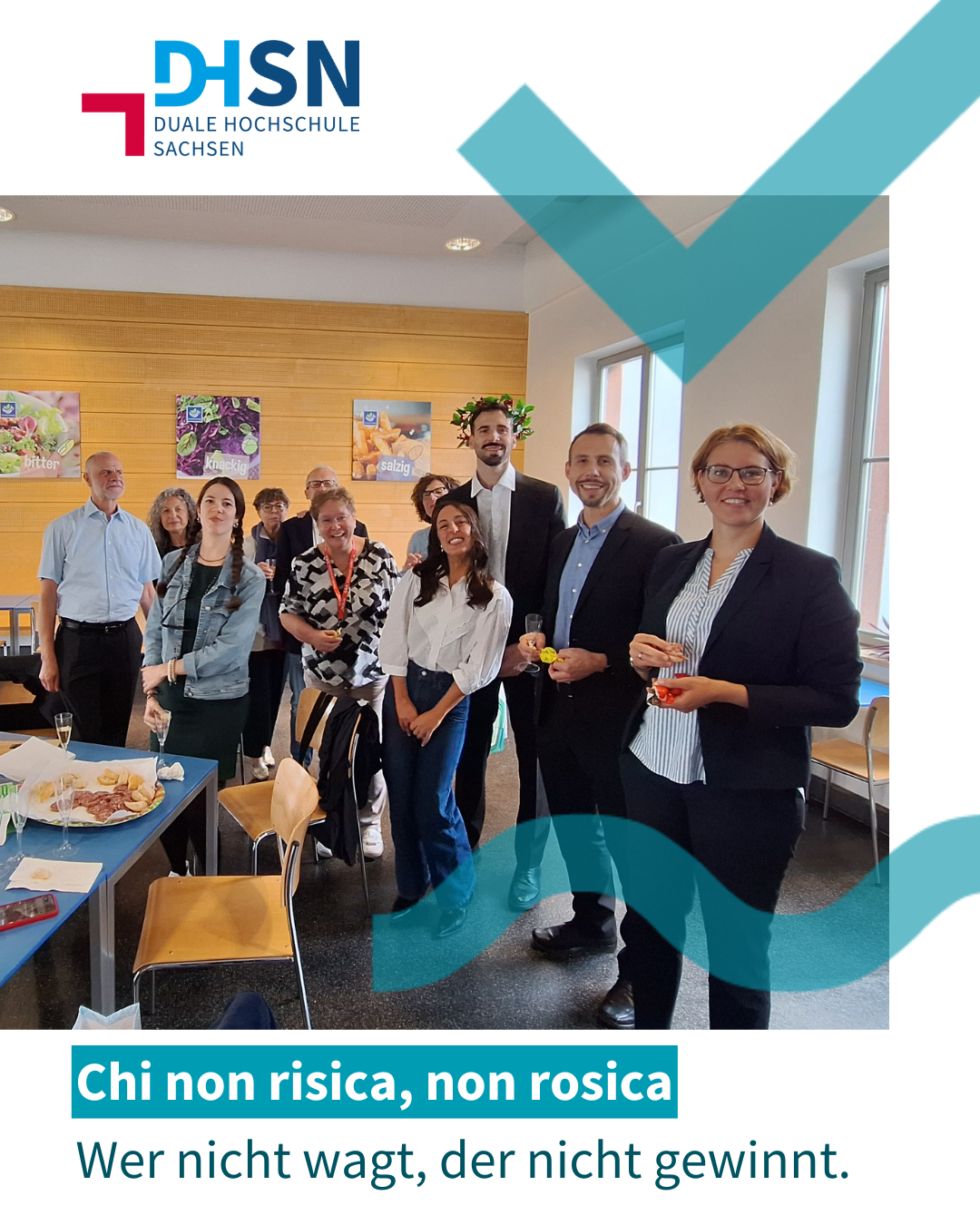 Gruppe von Personen in einem Raum mit Tischen und Stühlen, an der Wand bunte Poster, darunter Text 'Chi non risica, non rosica' und 'Wer nicht wagt, der nicht gewinnt.'